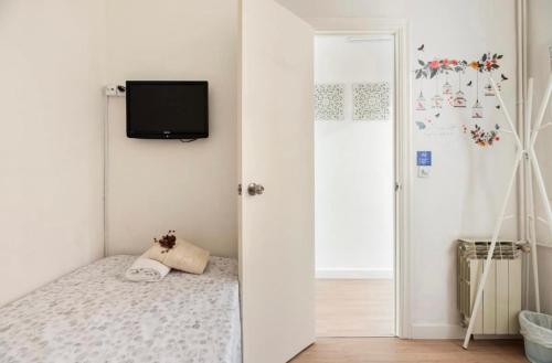 a bedroom with a bed and a tv on a wall at Quiet Love Suites in Barcelona
