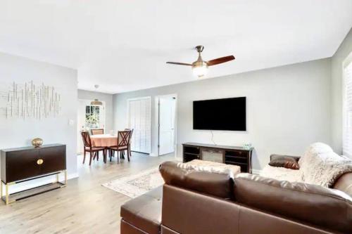 a living room with a couch and a flat screen tv at North Raleigh Private Retreat in Raleigh