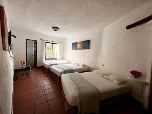 a group of four beds in a room at Mia Nueva Gorgona in Nueva Gorgona