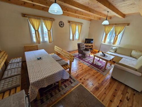 una sala de estar con una mesa y un sofá en Guest House Boka, en Žabljak
