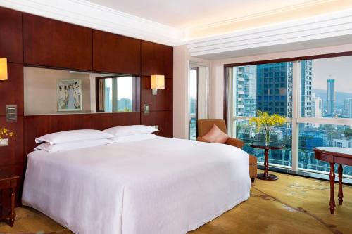 a bedroom with a large white bed and a large window at Sheraton Shenzhen Futian Hotel in Shenzhen