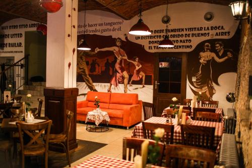 a living room with an orange couch and tables at Pokoje Gościnne u Klimosza in Pogwizdów