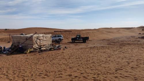 a jeep and a tent in the desert at Wüstencamp in Erg Chegaga in Mhamid
