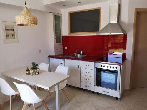 シヴォタにあるCasa Matinaの白いテーブルと赤い壁のキッチン