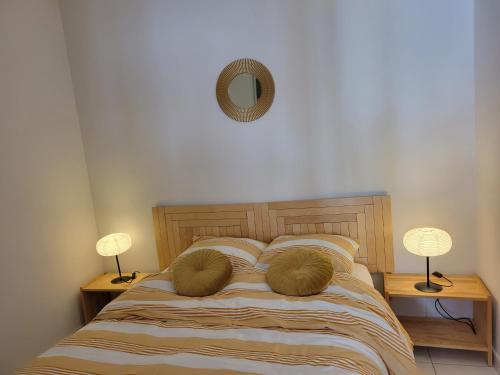 a bedroom with a bed with two lamps and a mirror at Appartement Lyon 7 Gerland in Lyon