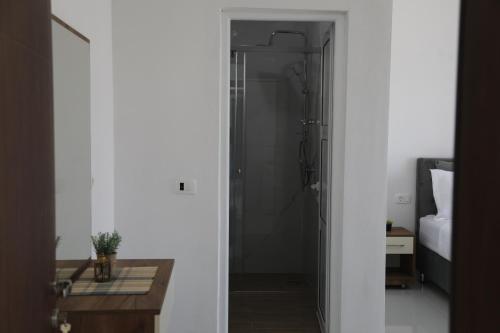 a bathroom with a shower and a table in a room at Villa Palace in Ulcinj