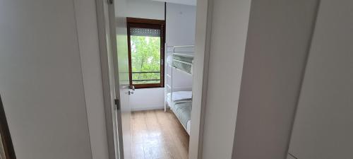 a room with a door open to a bedroom with a window at Casa do Sal in Troia