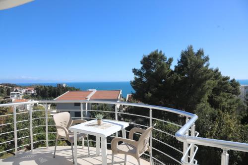 a balcony with a table and chairs and the ocean at Villa Palace in Ulcinj