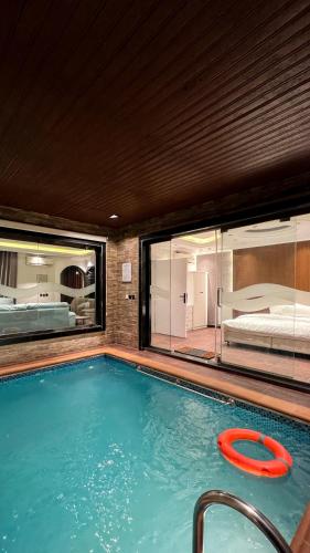 a large swimming pool with a bed in a bedroom at أبها مارينا فيلا in Abha