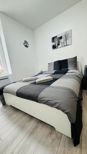 - un grand lit dans une chambre dotée d'un mur blanc dans l'établissement Nid Cozy, à Clermont-Ferrand