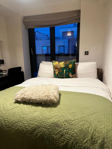 a bedroom with a large bed with a window at Chapel studios in Ilford
