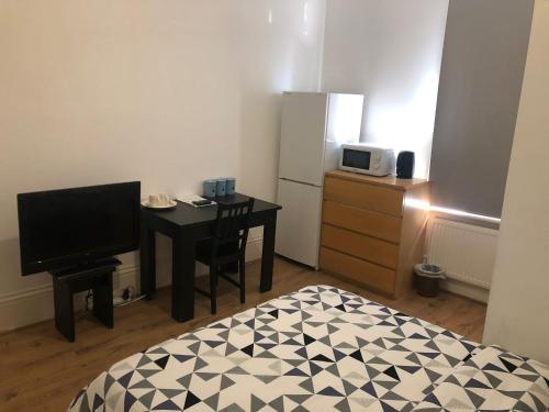 a small room with a desk and a television at London x DM Weekly x Monthly Discounts x W13 in Greenford