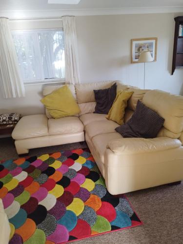 a living room with a couch and a colorful rug at lockwood house holiday cottages,Dawlish in Starcross