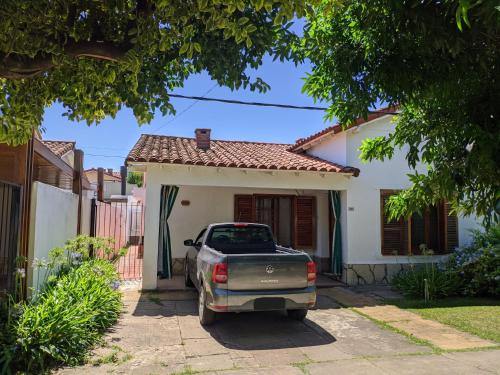 a truck parked in front of a white house at CASA BARRIO SOMISA in San Nicolás de los Arroyos