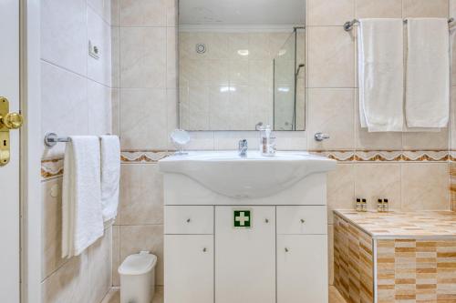 a white bathroom with a sink and a mirror at Candal Douro in Vila Nova de Gaia
