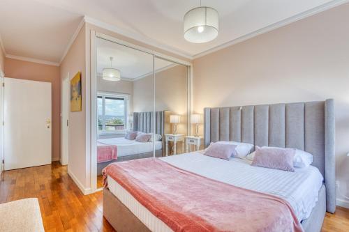 a bedroom with two beds and a large mirror at Candal Douro in Vila Nova de Gaia