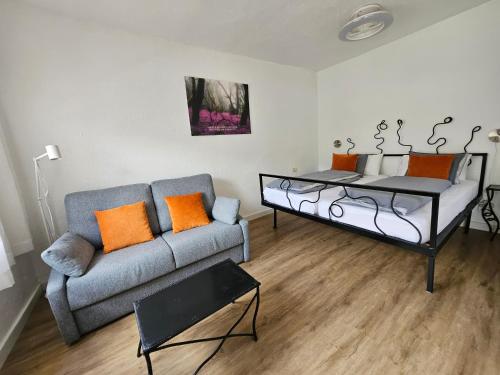 ein Wohnzimmer mit Sofa und orangefarbenen Kissen in der Unterkunft Casa Lara in Hermigua