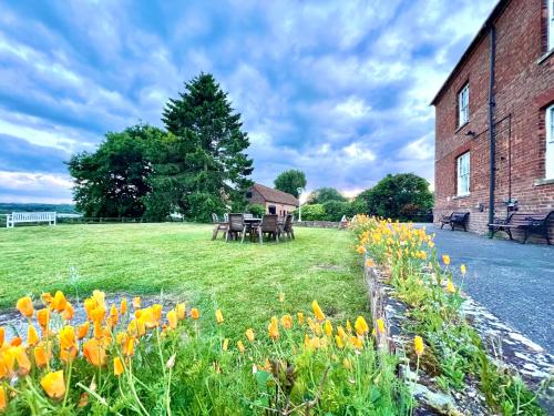 a field of flowers next to a brick building at Colthrop Manor with Gardens in Thatcham