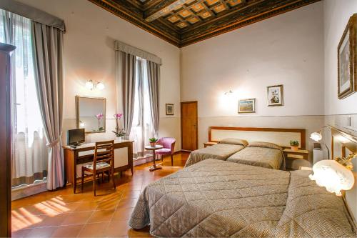 a bedroom with two beds and a desk with a computer at Hotel Arno Bellariva in Florence
