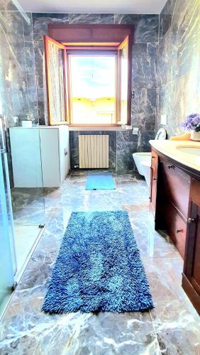 a bathroom with a blue rug on the floor at Villa Sartori in Legnago