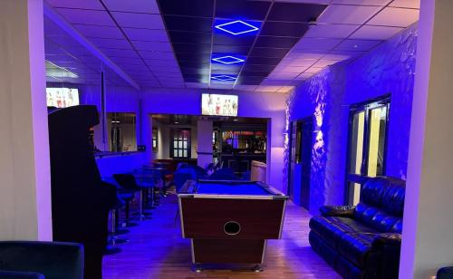 a room with a pool table and purple lighting at 100 Pipers Hotel in Blackpool