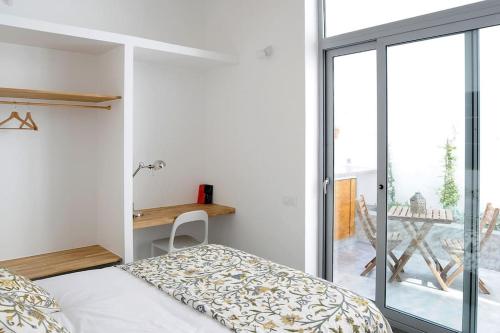 Schlafzimmer mit einem Bett und einer Glasschiebetür in der Unterkunft Architects Home By MyRentalHost in Barcelona