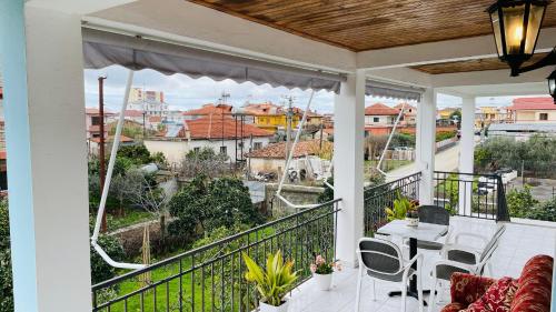 um pátio com uma mesa e cadeiras numa varanda em Mia Guest House - Entire home with balcony & garden em Divjakë