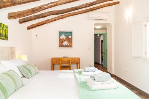 1 dormitorio con cama blanca y mesa en Casa rural "Cuenta la Leyenda..." en Bulbuente