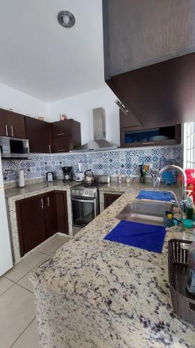 a kitchen with a granite counter top with a sink at House 5 min by the beach, with wide open garage. in Mazatlán