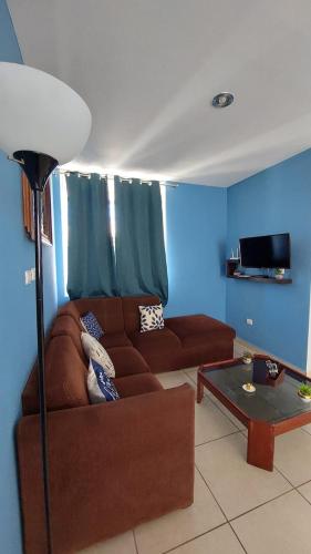a living room with a brown couch and a table at House 5 min by the beach, with wide open garage. in Mazatlán