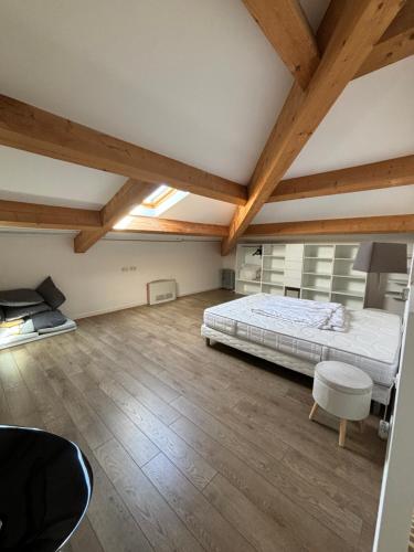 Cette grande chambre dispose d'un lit et de plafonds en bois. dans l'établissement Appartement centre ville, à Corte