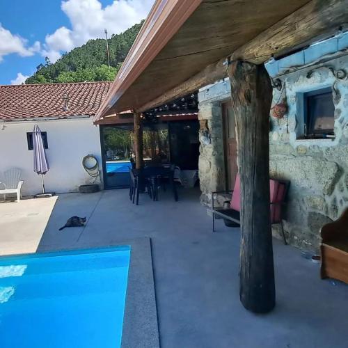 a patio with a swimming pool and a house at Casa do Garrano - Gerês in Vilar da Veiga