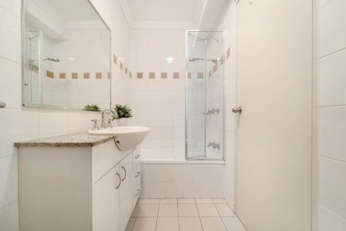 bagno bianco con lavandino e doccia di Walk to Coogee Beach Apartment Retreat a Sydney