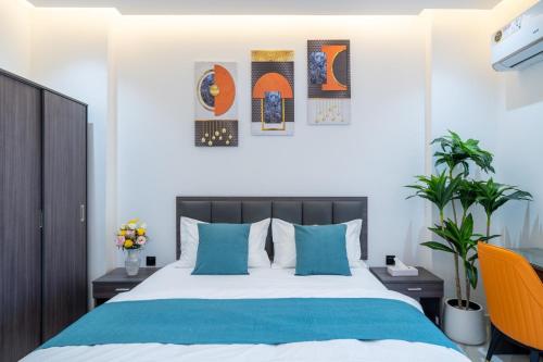 a bedroom with a large bed with blue pillows at جوهرة مسقط للشقق الفندقية in Ma‘ābīlah