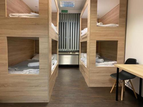 a room with four bunk beds with a desk at Hostel Messe Laatzen in Hannover