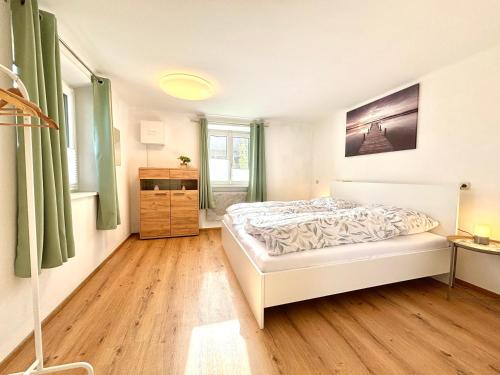 een slaapkamer met een bed en een houten vloer bij Gästhaus "Seeblick" in Seekirchen am Wallersee