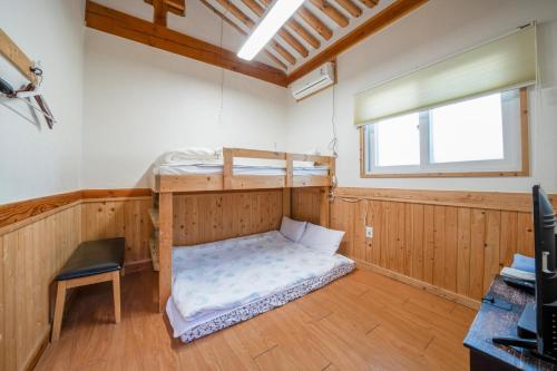 Habitación con litera y silla en Dorandoran Guesthouse, en Gyeongju