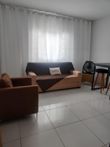 a living room with a couch and a table at Aconchego in Campo Grande