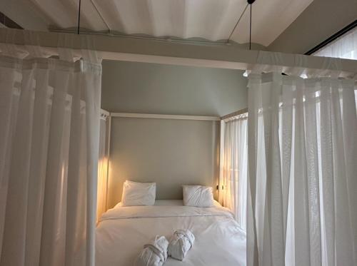 1 cama con sábanas blancas y cortinas blancas en una habitación en STYLISH APARTMENT OF HISTORY, en Estambul