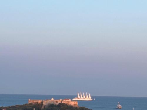 a group of boats in the ocean near a castle at Superbe 2 pièces Antibes vue mer, piscine, parking in Antibes