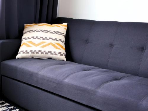 un sofá azul con una almohada encima en Logîtel Rimouski en Rimouski