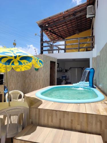 a pool with a water slide in a backyard at Casa Meu Cantinho in Barra de São Miguel