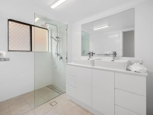 ein weißes Bad mit 2 Waschbecken und einer Dusche in der Unterkunft Ocean Outlook on Marine Parade in Kingscliff