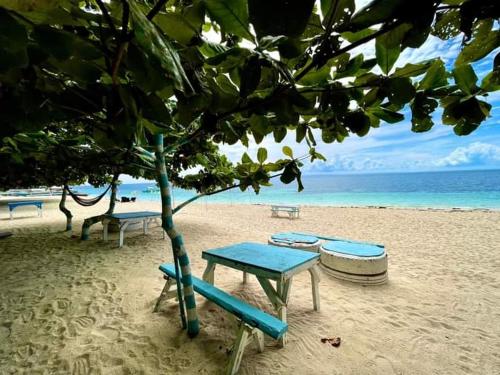 a picnic table and chairs on a beach at Camotes Island Beachfront Vacation House in San Francisco