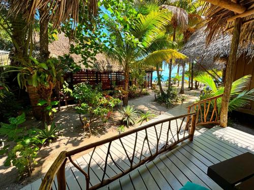 a wooden walkway leading to a resort with trees and plants at Azure Del Mar in Maya Beach
