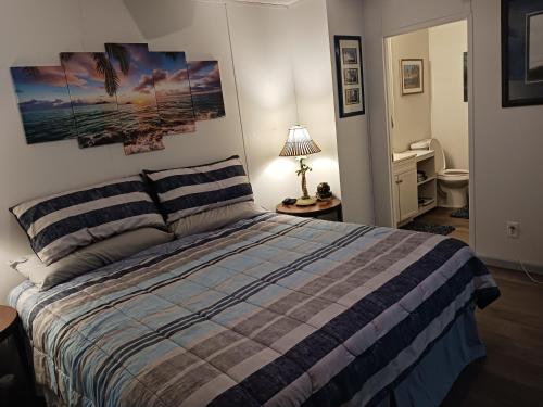 a bedroom with a bed with a striped comforter at Turtles Nest of Port Orange in Port Orange