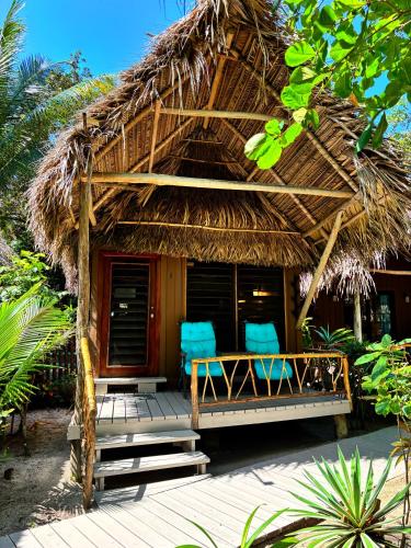 a resort with two chairs and a thatch hut at Azure Del Mar in Maya Beach
