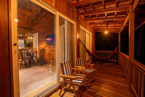 a porch of a cabin with two chairs and a hammock at Cabanas da Fazenda in Gramado