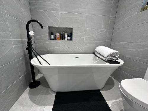 a white bath tub in a bathroom with a toilet at Tranquil Oasis in Gravesend, Kent in Northfleet