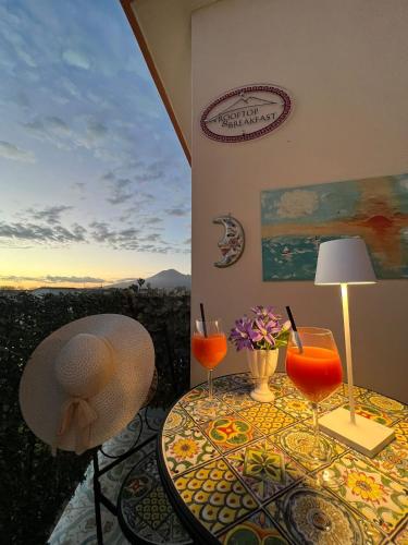 a table with two glasses of orange juice on it at Il Tempio Di Giove Suite Pompei in Pompei
